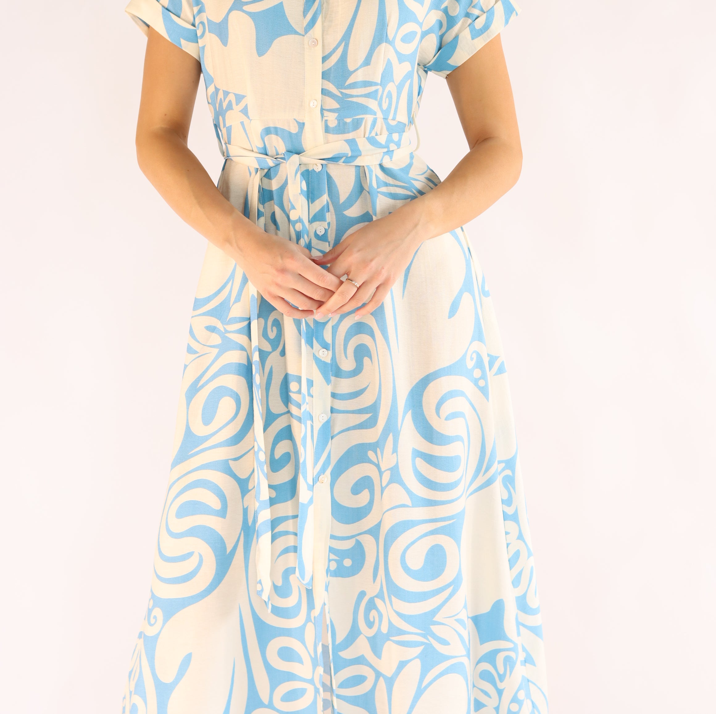 Woman wearing a blue and white patterned dress on a white background
