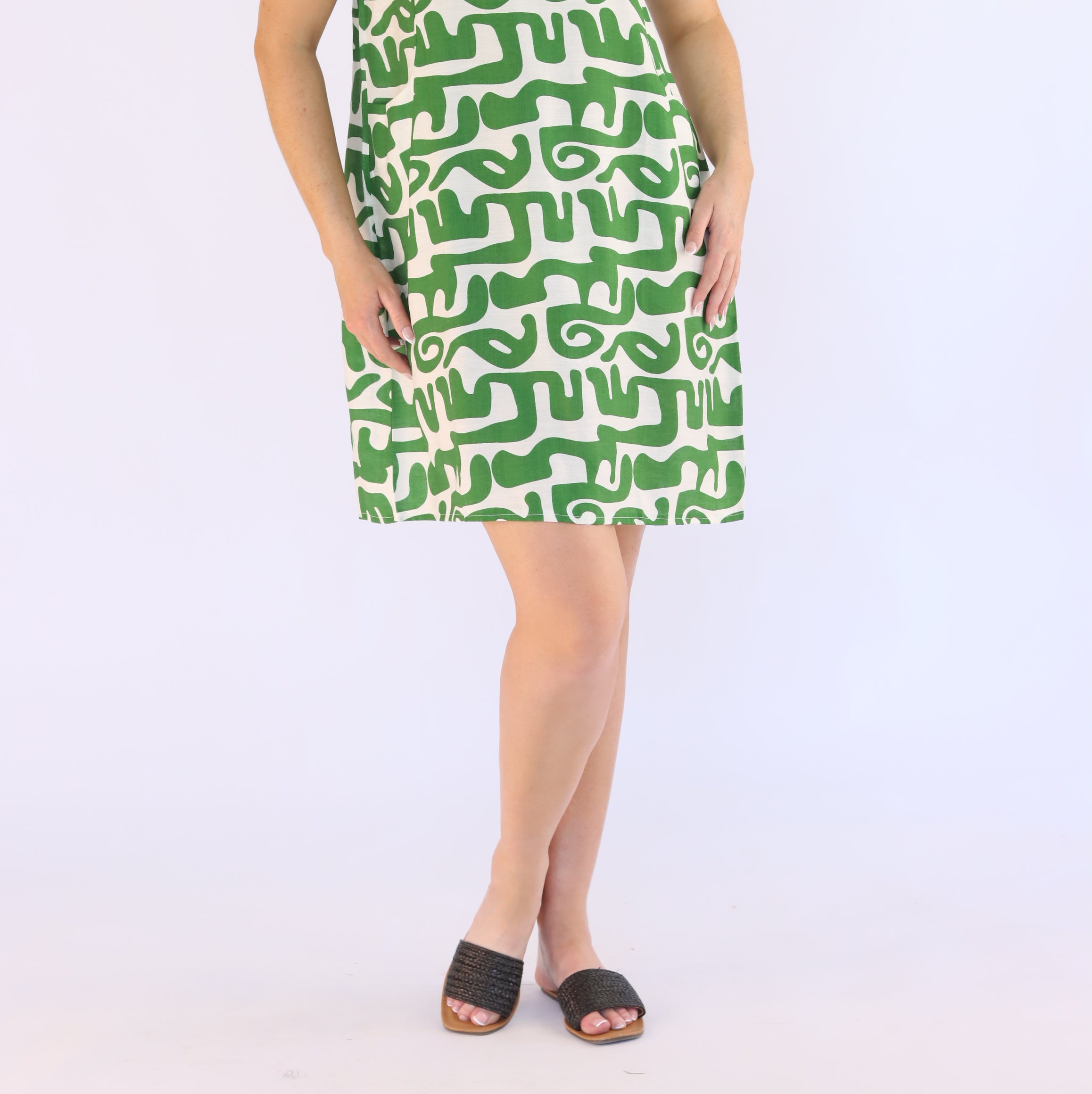 Woman wearing a green patterned dress on a white background