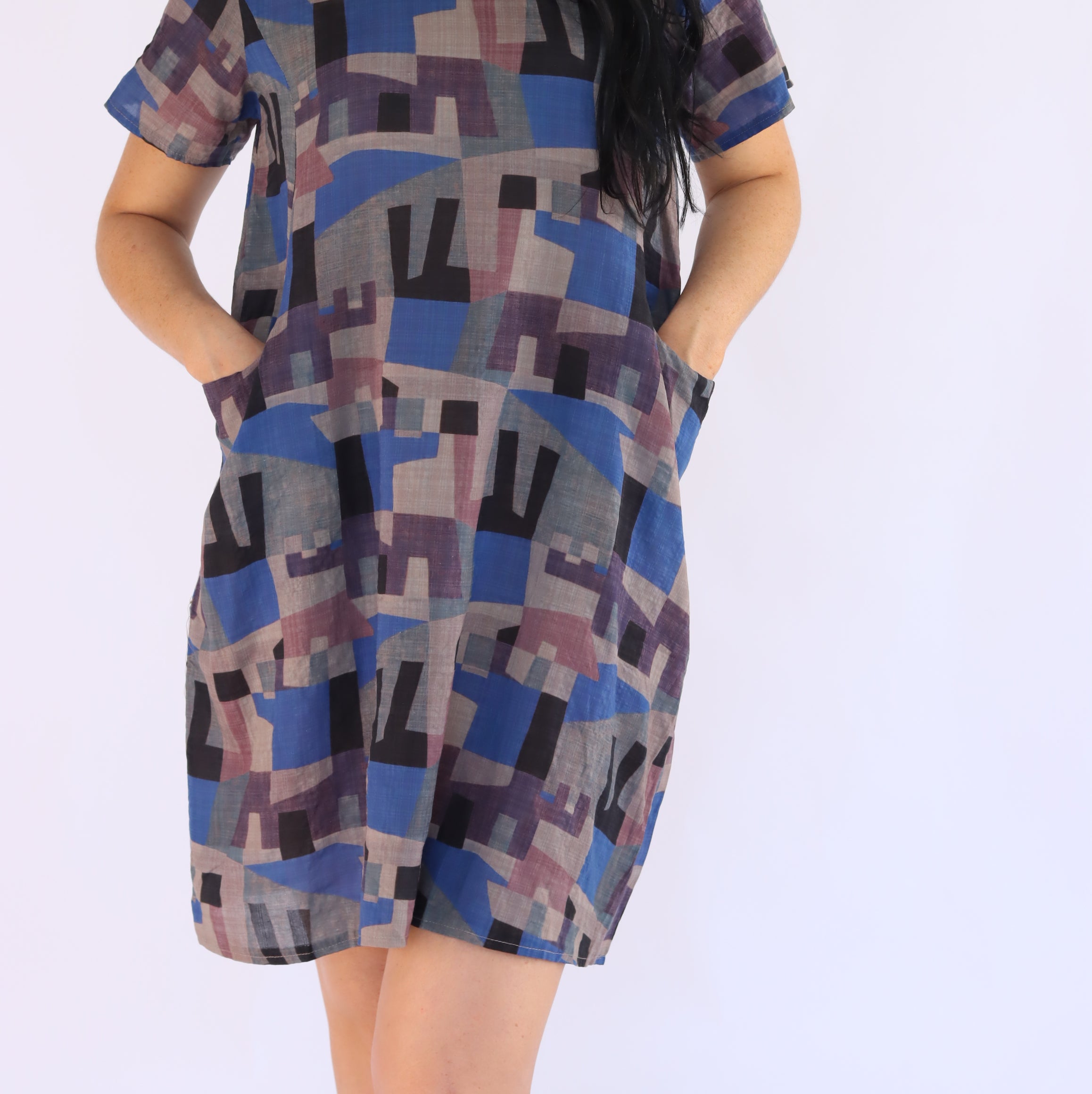 Woman wearing a patterned dress on a white background