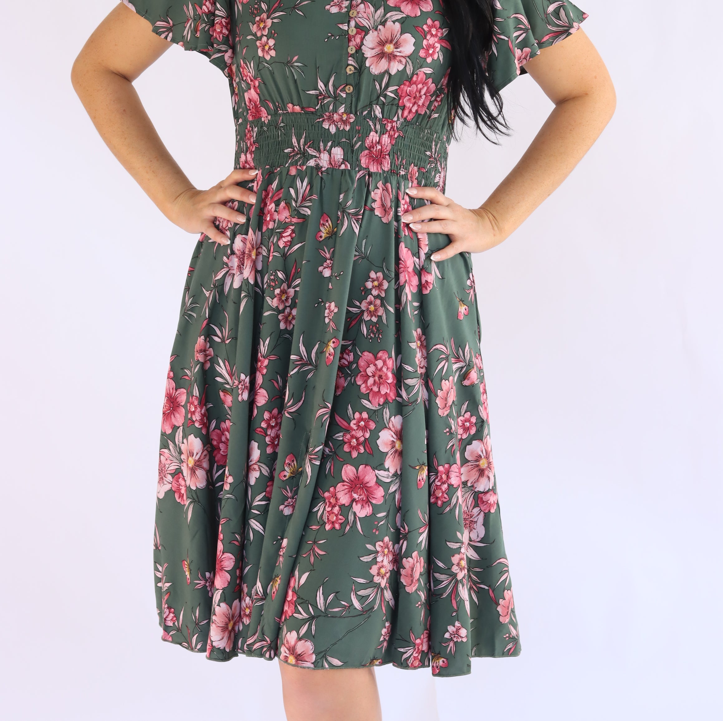 Woman wearing a green floral dress on a white background