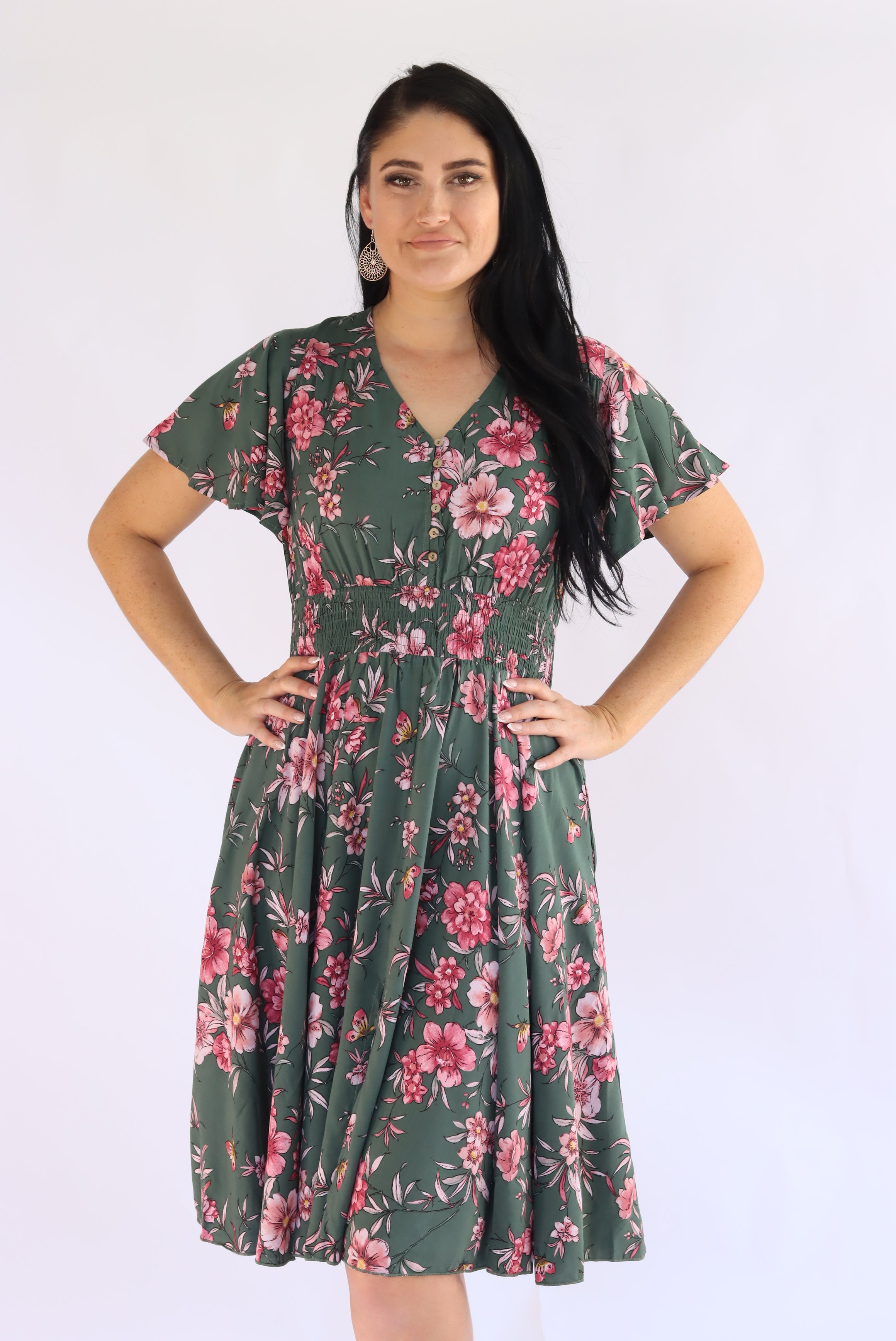 Woman wearing a green floral dress on a white background
