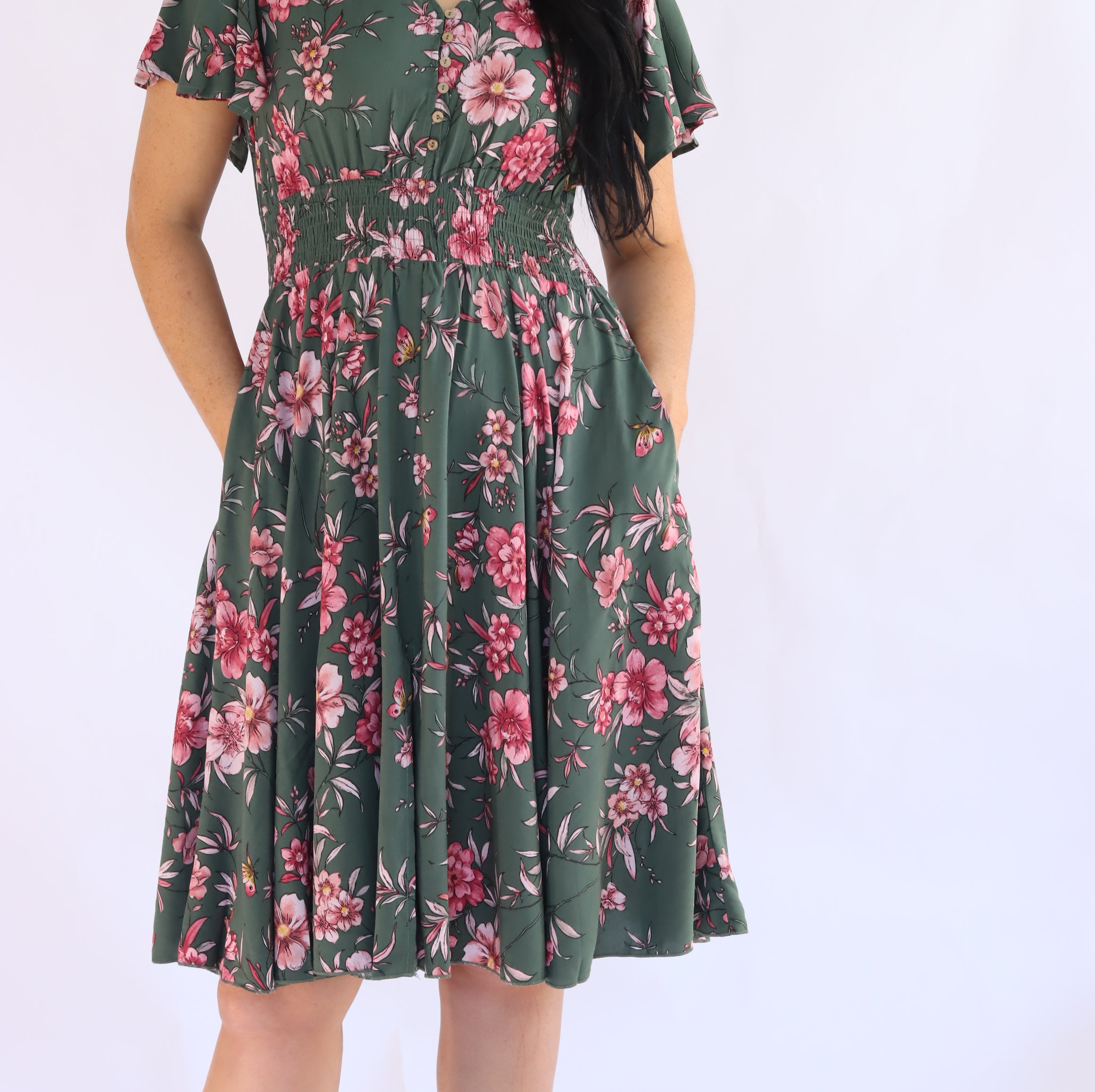 Woman wearing a green floral dress on a white background