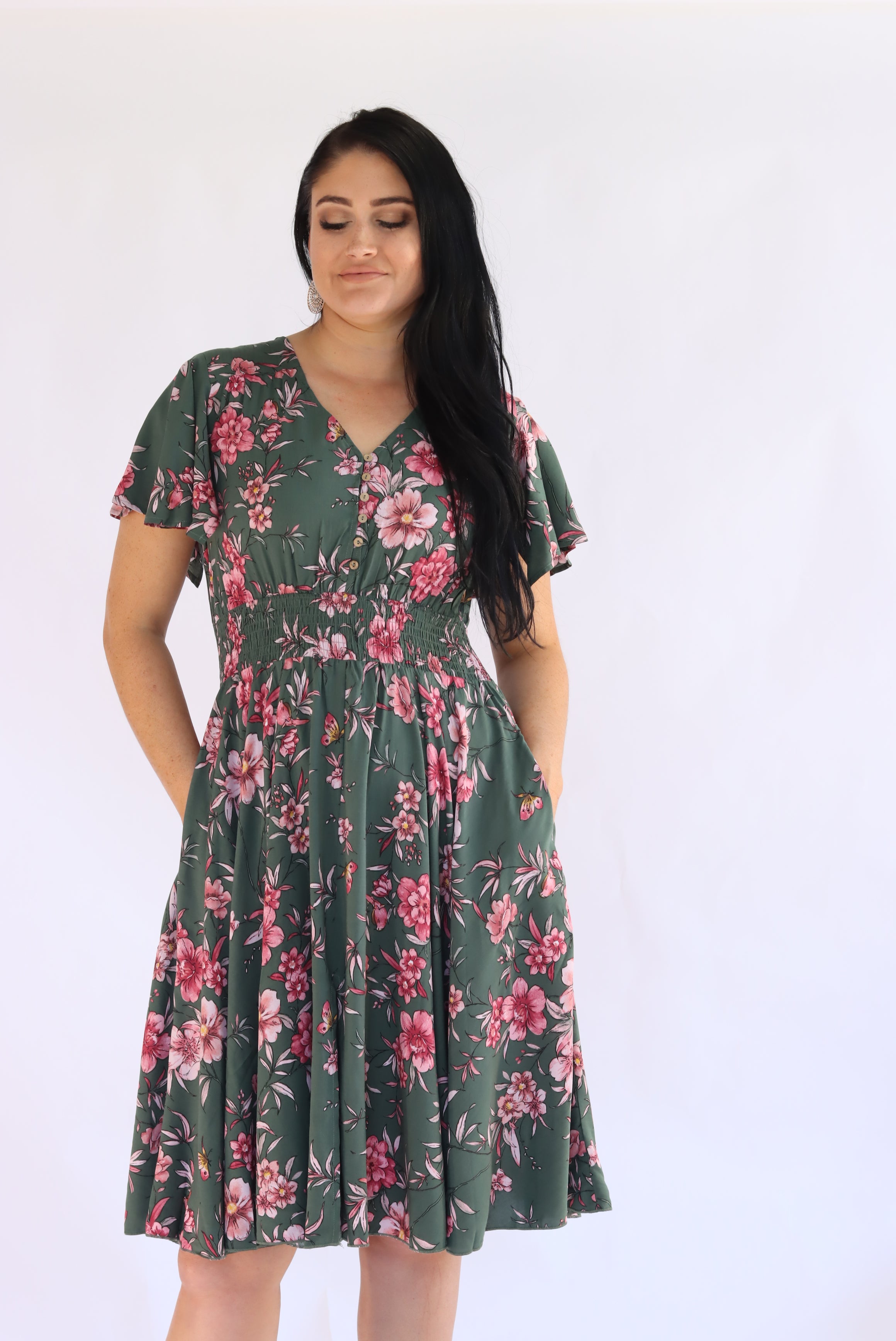 Woman wearing a green floral dress on a white background
