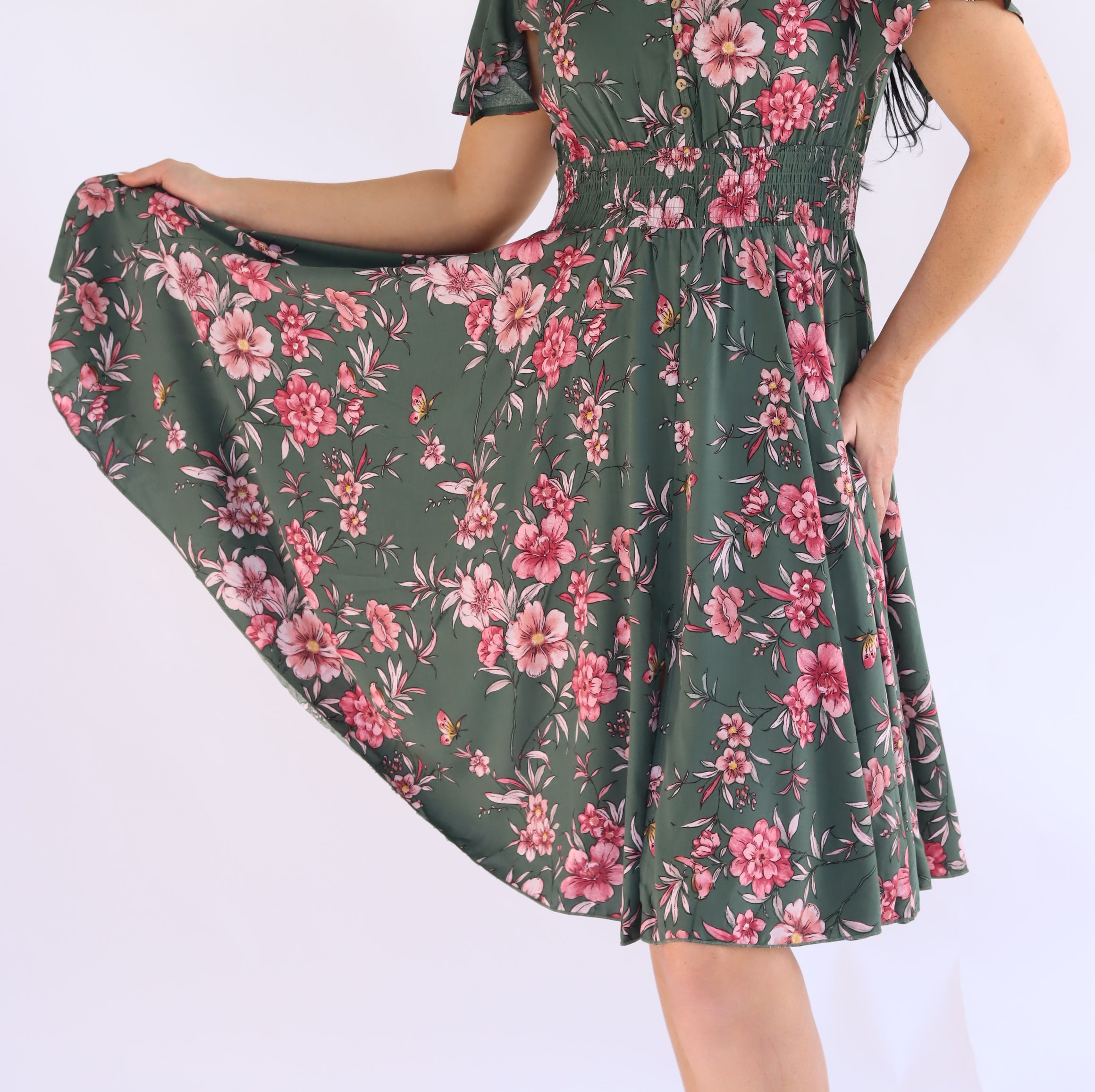 Woman wearing a green floral dress on a white background