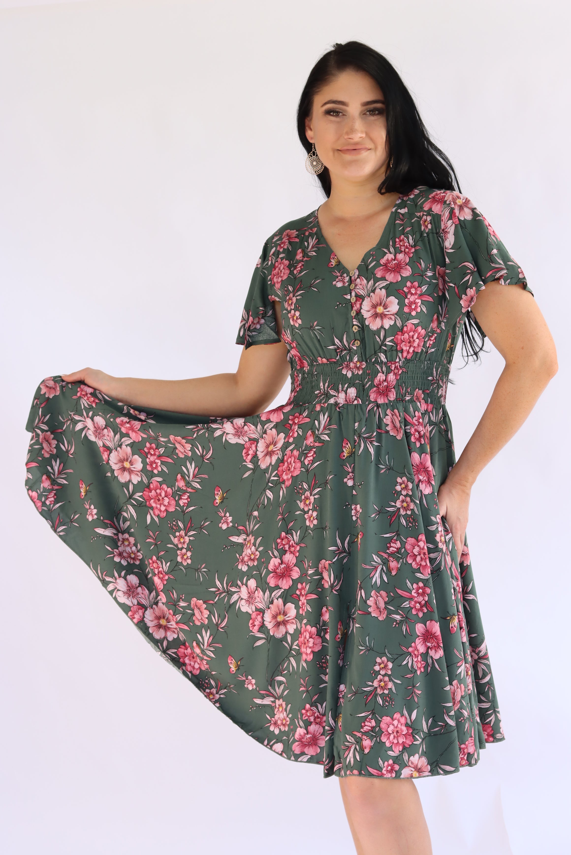 Woman wearing a green floral dress on a white background