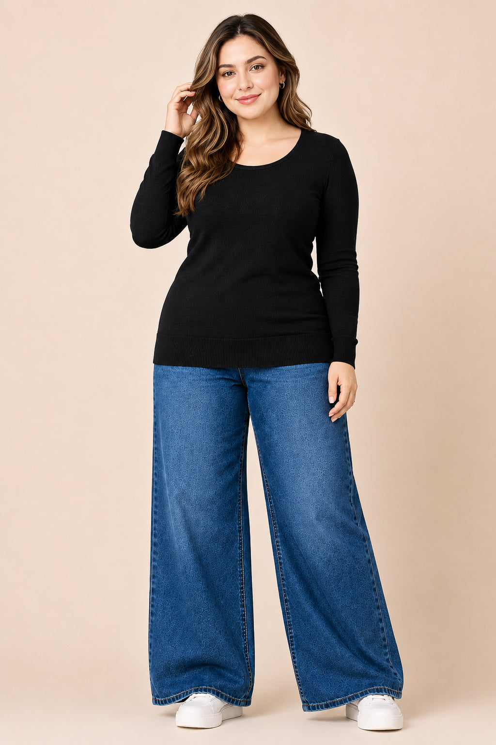 Woman wearing a black long-sleeve top and blue jeans on a beige background