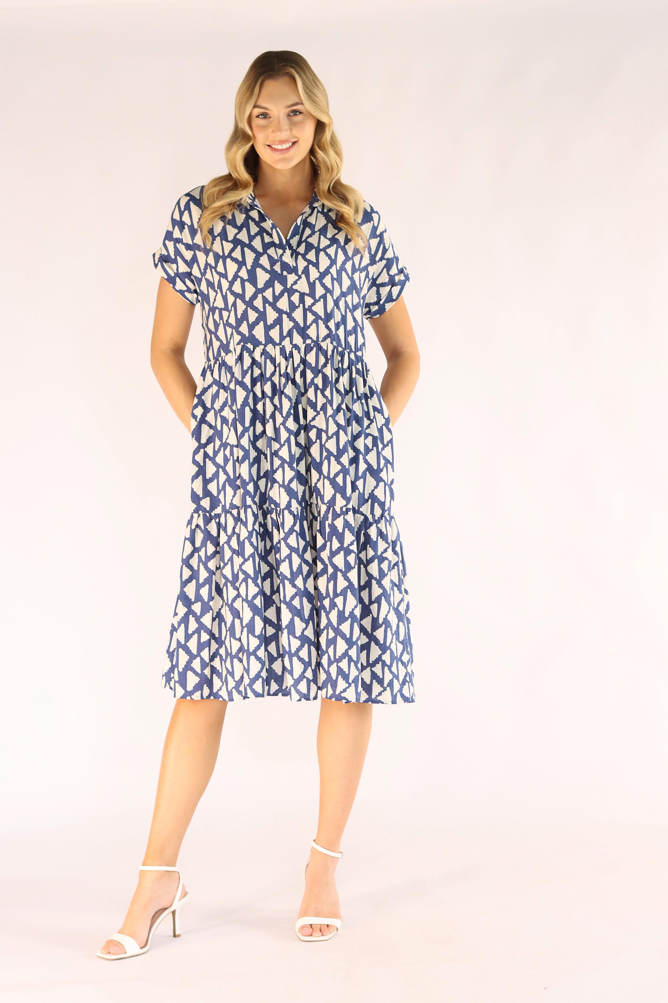 Woman wearing a blue patterned dress on a white background