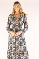 Woman wearing a long, patterned dress on a white background