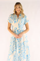 Woman wearing a blue and white patterned dress on a white background