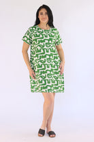 Woman wearing a green patterned dress on a white background
