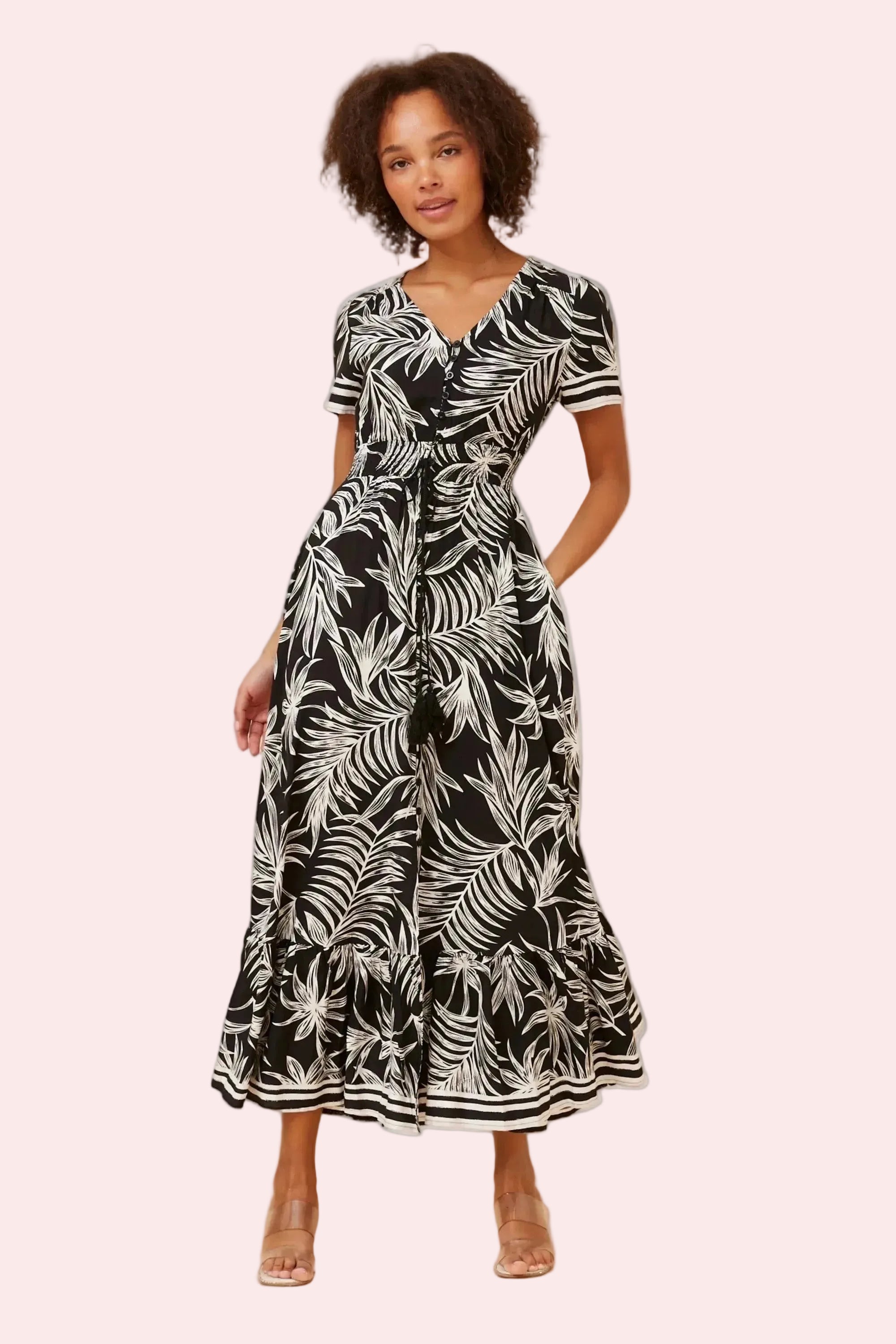 Woman wearing a black and white patterned dress on a beige background