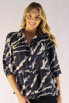 Woman wearing a patterned shirt against a plain background