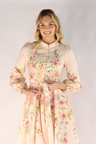 Woman wearing a floral dress against a plain background